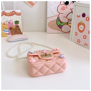 Dettaglio mini borsa in silicone rosa trapuntato con catena di perle e chiusura oro