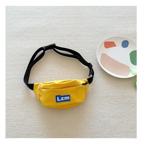 Detailed close-up of a bright yellow nylon kids waist bag with a blue Lzm logo patch