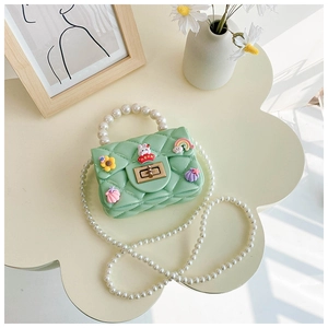 Detail of mint green silicone girl purse with pearl handle and sunflower decorations