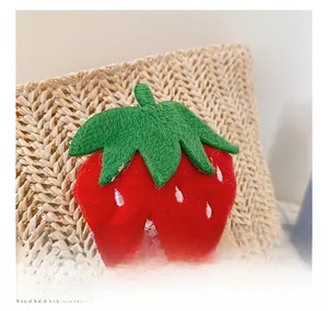 Close-up of cute strawberry embroidery detail on the woven straw bag for girls