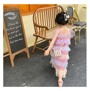 Detail of girls multi-layer ruffle tulle dress in pastel colors with pearl mini bag