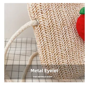 Macro view of woven straw bucket bag with silver grommets and thick cotton rope strap