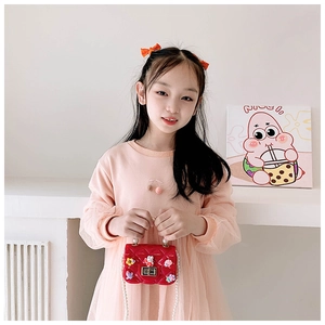 Girl carrying red quilted silicone bunny bag with pearl strap and cute charms