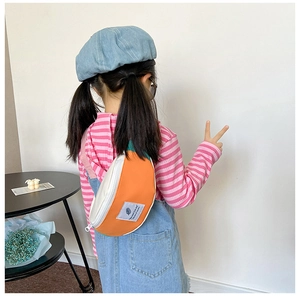 Vue arrière d'un enfant portant un sac bandoulière en toile orange et bleu contrasté