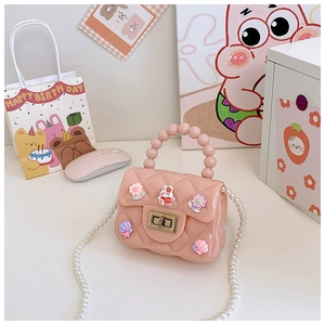 Dettaglio borsa in silicone rosa gelatina con manico di perle e ciondoli a cartone animato