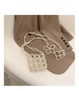 Detail of hand-woven pearl crossbody bag for girls with delicate floral pearl accents
