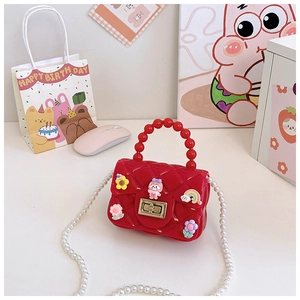 Detail of red jelly bag with diamond texture, pearl strap and cute 3D cartoon charms