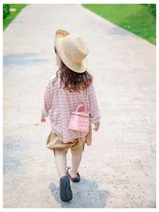 Girl's pink mini jelly crossbody bag with gold chain and diamond texture in outdoor scene