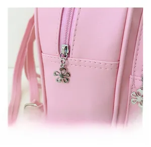 Detailed close-up of smooth pink zipper and silver flower-shaped metal pull on PU leather bag