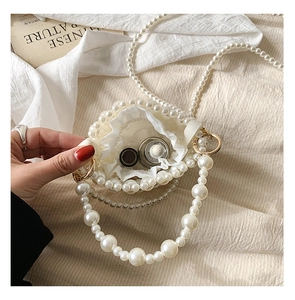 Detailed macro view of woven pearl mini bucket bag with drawstring pouch and beaded strap