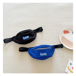 Detail view of mini nylon waist bags in black and blue with Lzm letter patches