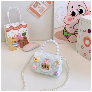 Detail of white jelly bag featuring 3D floral charms and round pearl handle