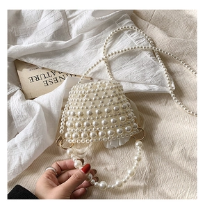 Detail of handmade woven pearl bag featuring gold hardware and silk lining for girls