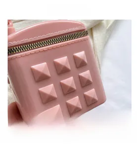 Detail of pink silicone bag with gold pyramid studs and metallic zipper closure