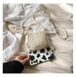 Detail view of a handmade pearl woven mini bag with a long beaded chain and satin lining