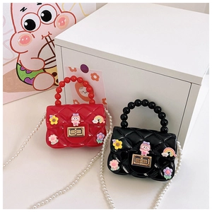 Detail of red and black quilted jelly bags with pearls and cartoon charms for girls