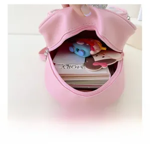 Interior view of small pink PU backpack showing capacity for phone and notebook