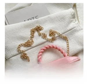 Detail of pink mini quilted bucket bag with golden chain and twisted handle top view