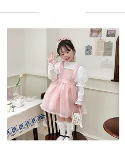 Detail of pink organza dress with pearl handbag on child model in soft home setting