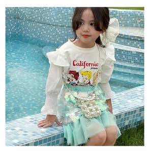 Detail of girls' outfit with sequin mint skirt, printed top and pearl chain handbag