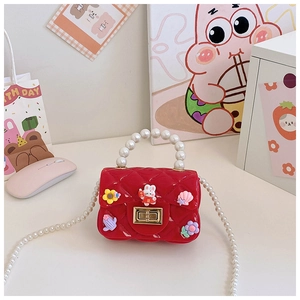 Detail of red quilted jelly bag for girls with pearl handle and cartoon rabbit charms