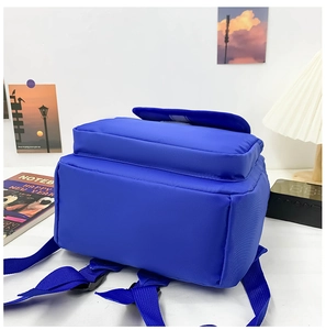 Detail view of royal blue canvas backpack showing durable straps and bottom structure
