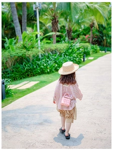 Pink quilted mini bag paired with striped top and straw hat for a summer holiday look