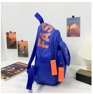 Detail of royal blue kids backpack showing orange FASH letters and side pocket texture