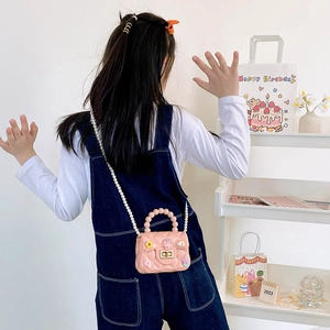 Pink cartoon jelly bag for girls with pearl chain and floral charms on a model