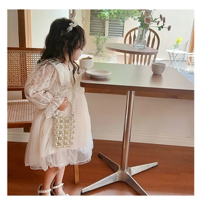 Detail of girls princess lace dress with tiered tulle skirt and pearl accessory handle
