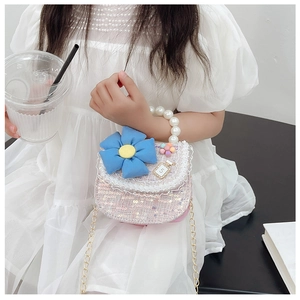 Détail du sac fille en paillettes roses avec fleur bleue et poignée en perles sur modèle