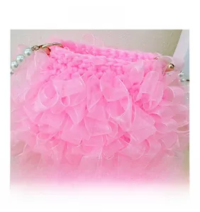 Detail der rosa Rüschen-Organza-Tasche mit elegantem weißem Perlengriff und Bogen