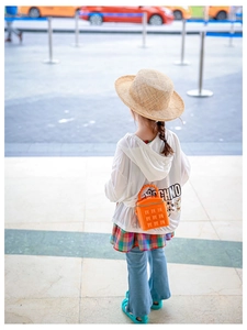 Detail of a bright orange mini square bag paired with a stylish girls' streetwear outfit