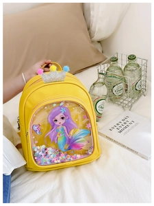 Detail of yellow toddler backpack with mermaid glitter pocket and colorful plush balls