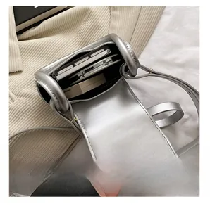 Silver metallic saddle bag showing interior capacity for two phones and makeup compact