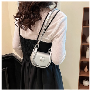 Mini sac bandoulière argenté avec cœur métallisé porté par un mannequin de dos