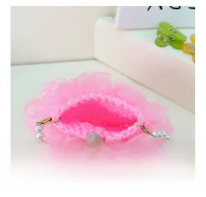 Detail der rosa Webfütterung und des Perlenriemens der Organza-Mädchentasche im Inneren
