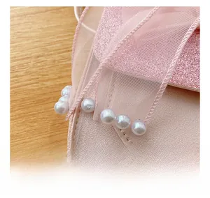 Detail view of pink PU leather girls purse with pearl charm and glitter mesh texture