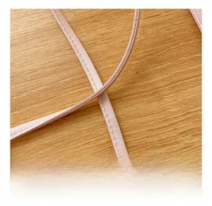 Close-up of the adjustable pink PU leather strap with detailed stitching on wood background