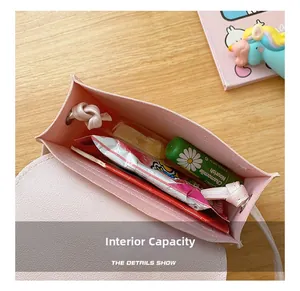 Internal capacity of pink PU leather mini crossbody bag for kids showing small snacks