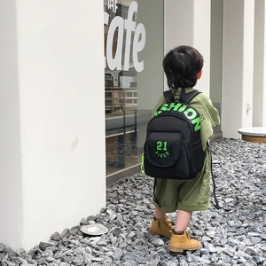 Black canvas preschool backpack for boys with neon green fashion lettering on the street