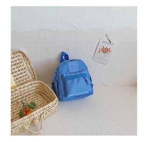 Detail of blue nylon toddler backpack with front zipper pocket and GIRL CATS logo