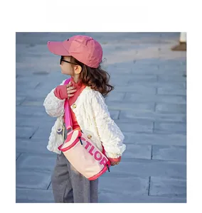 Vue détaillée du sac à bandoulière rose et beige avec l'imprimé de lettres TLOP