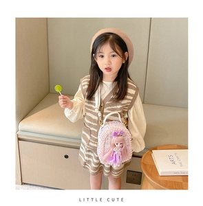 Detail of pink and white tweed kids crossbody bag with pearl trim and a cute doll charm
