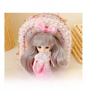 Detailed view of girl's pink tweed mini bag with pearl lace and cute doll ornament