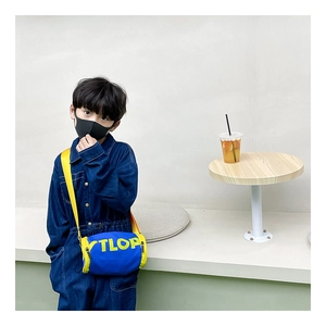 Détail du sac cylindrique enfant bleu et jaune avec bandoulière réglable et lettres