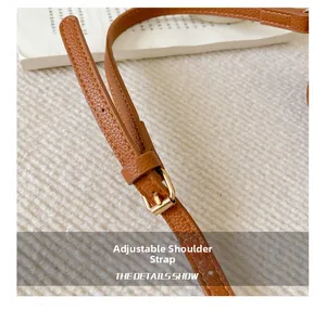 Détail du sac en similicuir marron avec bandoulière réglable et boucle en métal doré