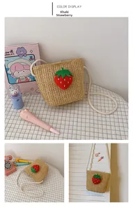 Detail of handmade khaki woven straw bag for girls featuring a cute red plush strawberry