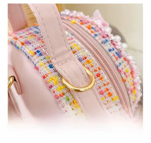 Detail of pink tweed girl crossbody bag featuring white pearls and neat stitching
