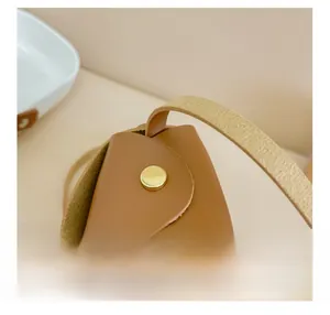 Close-up of brown leather bag with gold metal buckle and meticulous edge stitching